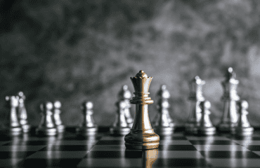 Gold and silver chess on chess board on black and white marble background