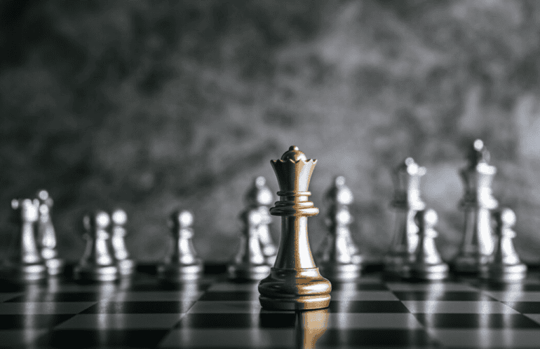 Gold and silver chess on chess board on black and white marble background